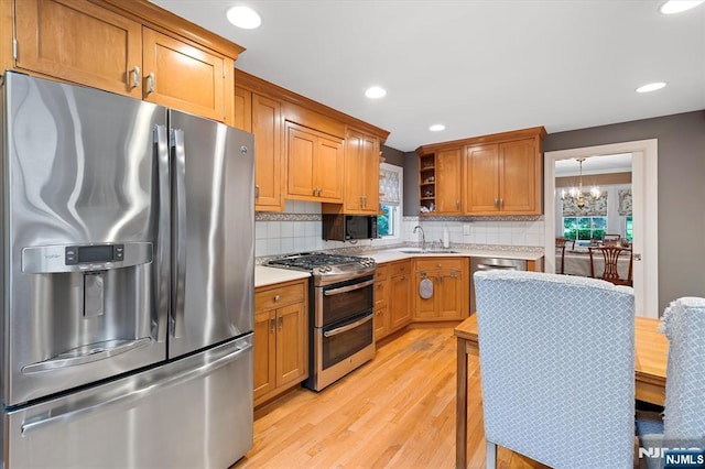 747 Mildred St, Teaneck, NJ 07666 - kitchen featuring appliances with stainless steel finishes, open shelves, light countertops, light wood-type flooring, and backsplash