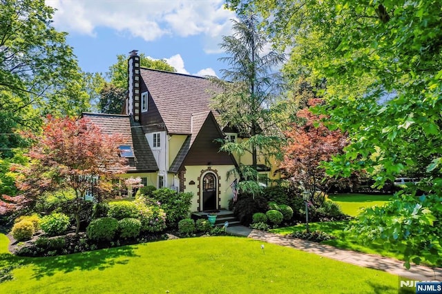 747 Mildred St, Teaneck, NJ 07666 - tudor home with stucco siding, a front yard, and a chimney