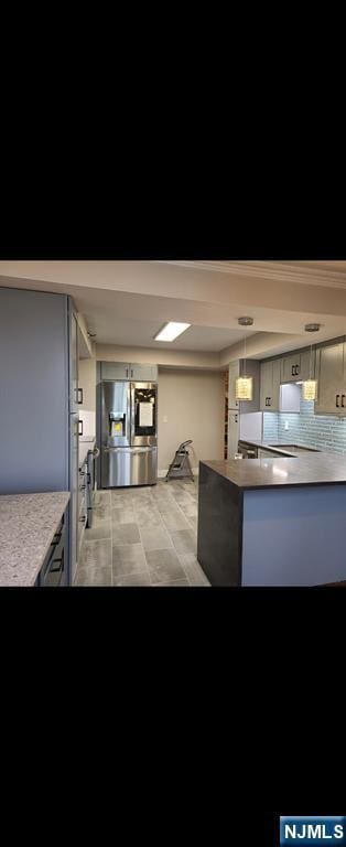 1265 15th Unit 11L, Fort Lee, NJ 07024 - kitchen with stainless steel fridge, a peninsula, backsplash, light countertops, and hanging light fixtures