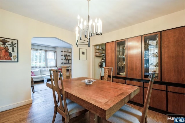 279 Jefferson Ave, Cresskill, NJ 07626 - dining area featuring wood finished floors, arched walkways, and a chandelier