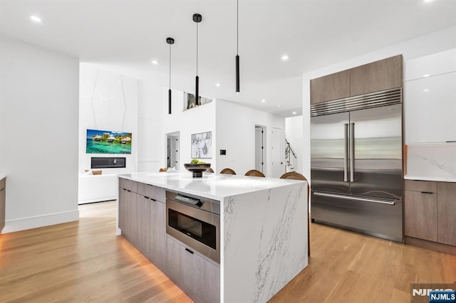 404 Willard Rd, Paramus, NJ 07652 - kitchen with built in appliances, modern cabinets, light wood finished floors, pendant lighting, and recessed lighting