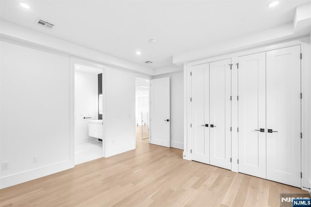 404 Willard Rd, Paramus, NJ 07652 - unfurnished bedroom with multiple closets, recessed lighting, light wood-type flooring, and ensuite bath