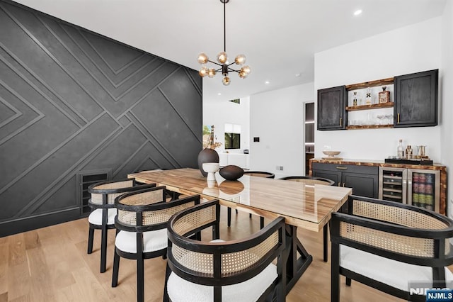 404 Willard Rd, Paramus, NJ 07652 - dining space featuring bar, a chandelier, light wood-type flooring, wine cooler, and a decorative wall