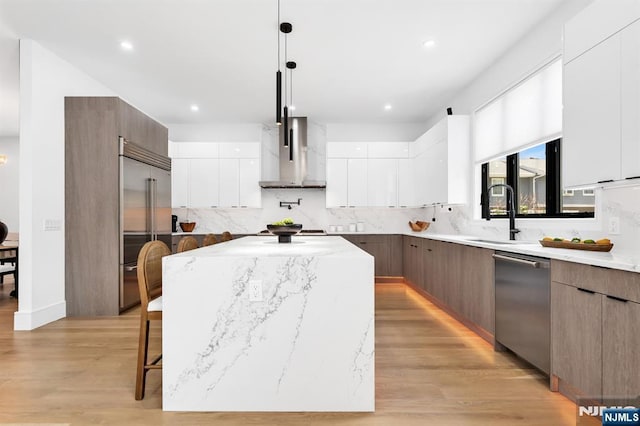404 Willard Rd, Paramus, NJ 07652 - kitchen with modern cabinets, wall chimney exhaust hood, stainless steel appliances, a kitchen island, and recessed lighting