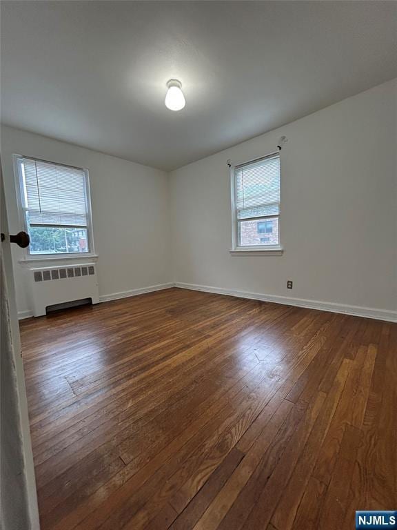 22 Cedar St Unit 2B, Ridgefield Park, NJ 07660 - unfurnished room with radiator, plenty of natural light, and dark wood-style floors