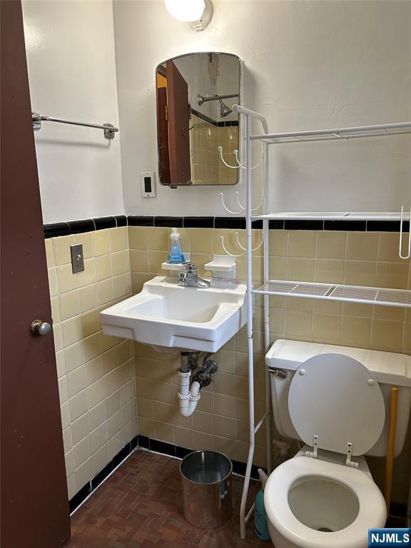 22 Cedar St Unit 2B, Ridgefield Park, NJ 07660 - bathroom featuring tile walls and wainscoting