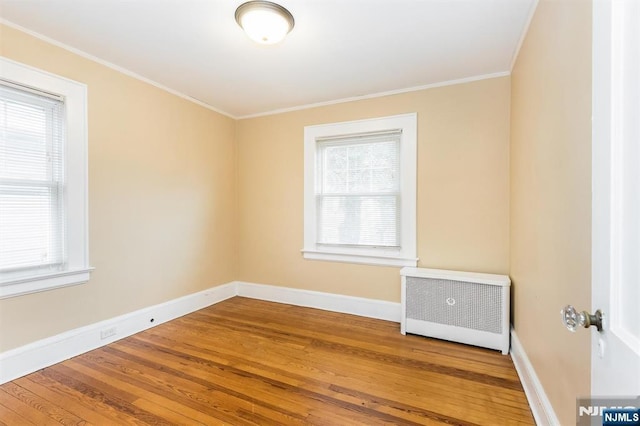 39 Lexington Ave, Bloomfield, NJ 07003 - empty room with wood finished floors, healthy amount of natural light, radiator heating unit, and ornamental molding
