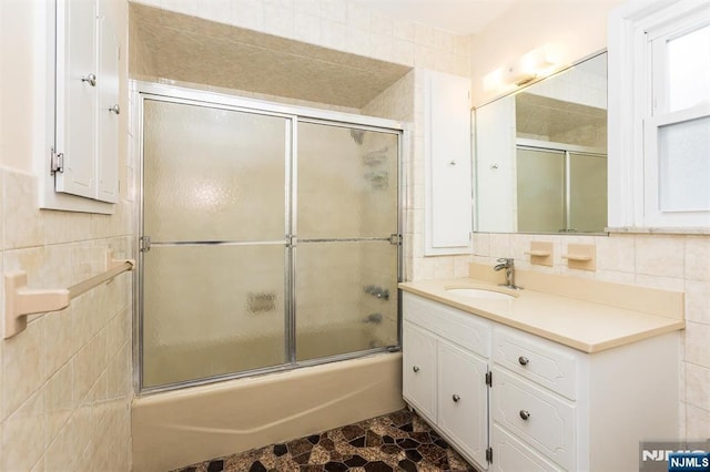 39 Lexington Ave, Bloomfield, NJ 07003 - bathroom featuring vanity, combined bath / shower with glass door, and tile walls