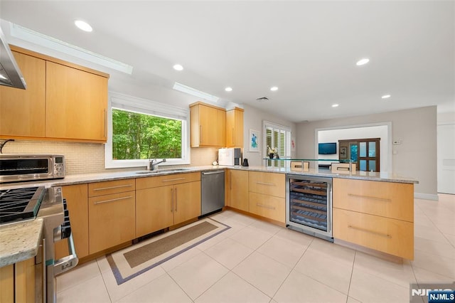 811 Domm Ct, Wyckoff, NJ 07481 - kitchen with wine cooler, a peninsula, light brown cabinets, stainless steel dishwasher, and stove