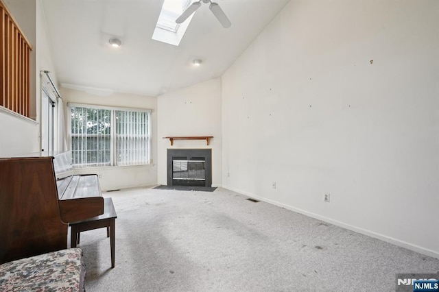 71 Butternut Dr Unit 71, Wayne, NJ 07470 - unfurnished living room with vaulted ceiling, ceiling fan, carpet, a fireplace with flush hearth, and a skylight