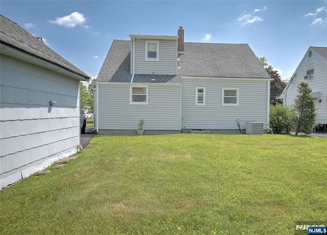 23 Bromley Pl, Bloomfield, NJ 07003 - back of property featuring a lawn, a chimney, and a shingled roof
