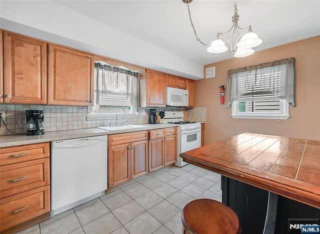 23 Bromley Pl, Bloomfield, NJ 07003 - kitchen featuring white appliances, a chandelier, backsplash, light countertops, and brown cabinetry