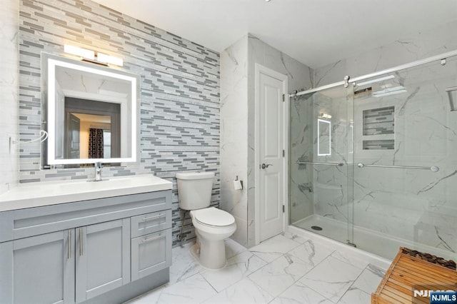 5711 Jefferson St Unit 405, West New York, NJ 07093 - bathroom featuring marble look tile flooring, a marble finish shower, vanity, and tile walls