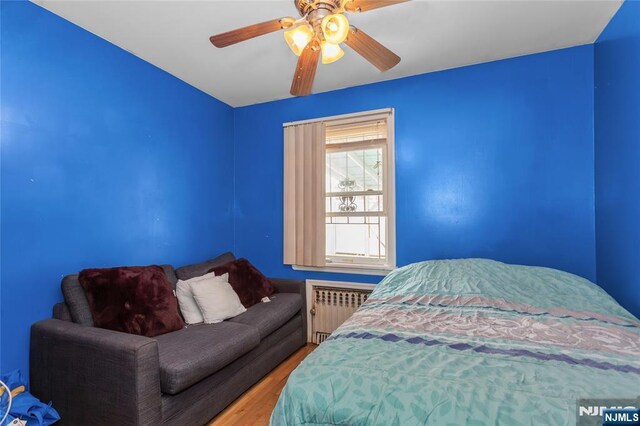 320 Clifton Ave, Newark, NJ 07104 - bedroom featuring radiator, wood finished floors, and a ceiling fan