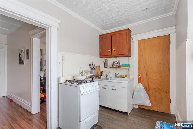 320 Clifton Ave, Newark, NJ 07104 - kitchen featuring white gas stove, wood finished floors, an ornate ceiling, light countertops, and brown cabinetry