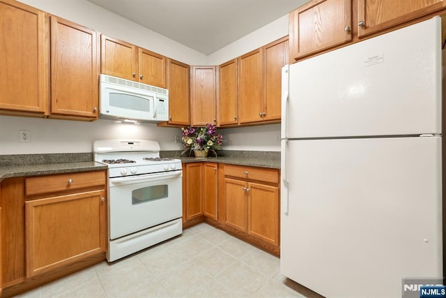 7303 Ravenscroft Rd Unit 570, Clifton, NJ 07013 - kitchen with white appliances, dark countertops, and brown cabinetry