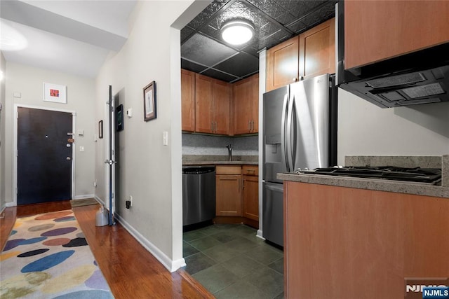 187 Wayne St Unit 405, Jersey City, NJ 07302 - kitchen featuring appliances with stainless steel finishes, extractor fan, dark wood-type flooring, and brown cabinets