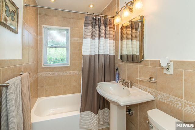 20 Goss Pl, Clifton, NJ 07013 - bathroom with tile walls and shower / bathtub combination with curtain