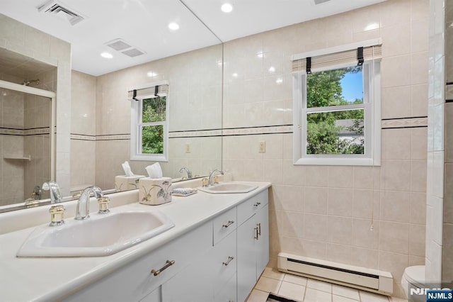506 Salem St, Paramus, NJ 07652 - full bath featuring a baseboard heating unit, tile walls, double vanity, plenty of natural light, and tile patterned floors