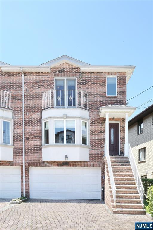 400 Lawton Ave Unit C0400, Cliffside Park, NJ 07010 - view of front of house with a garage, decorative driveway, brick siding, and stairs