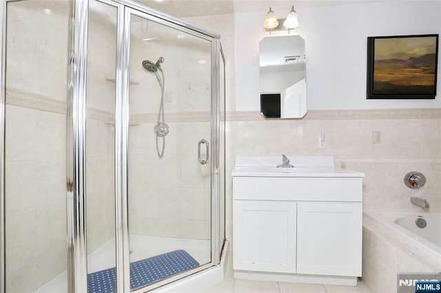 400 Lawton Ave Unit C0400, Cliffside Park, NJ 07010 - full bathroom featuring a stall shower, a bath, vanity, tile walls, and wainscoting