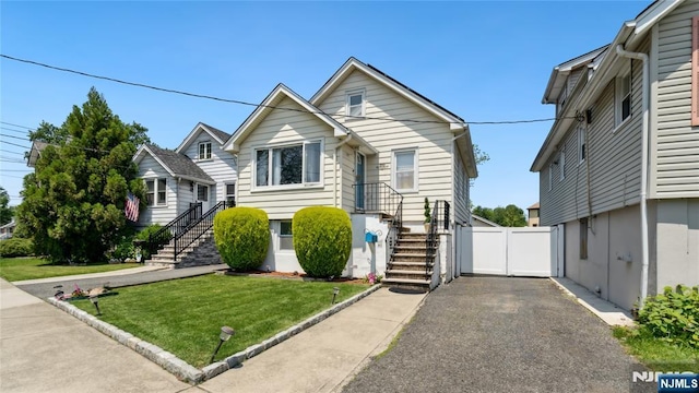 80 Union Ave, Little Ferry, NJ 07643 - view of front facade featuring stairway, a front yard, a garage, and asphalt driveway