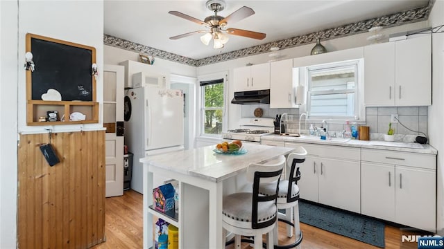 80 Union Ave, Little Ferry, NJ 07643 - kitchen with under cabinet range hood, white appliances, tasteful backsplash, white cabinets, and light wood-style floors