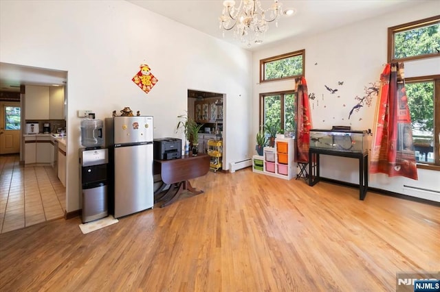 699 Shore Rd, West Milford, NJ 07421 - kitchen featuring freestanding refrigerator, a chandelier, plenty of natural light, light wood-type flooring, and a towering ceiling