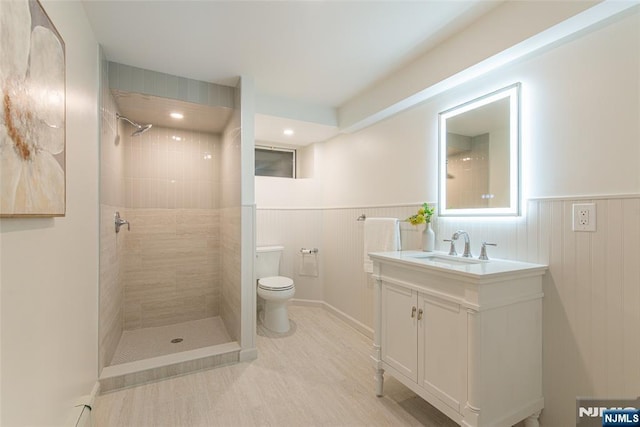 146 Raab Ave, Bloomfield, NJ 07003 - full bath with vanity, a tile shower, a wainscoted wall, and wood finished floors