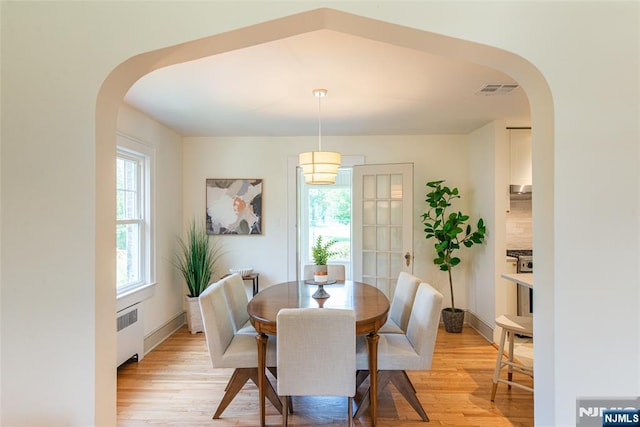 146 Raab Ave, Bloomfield, NJ 07003 - dining space with radiator, light wood-style floors, and arched walkways
