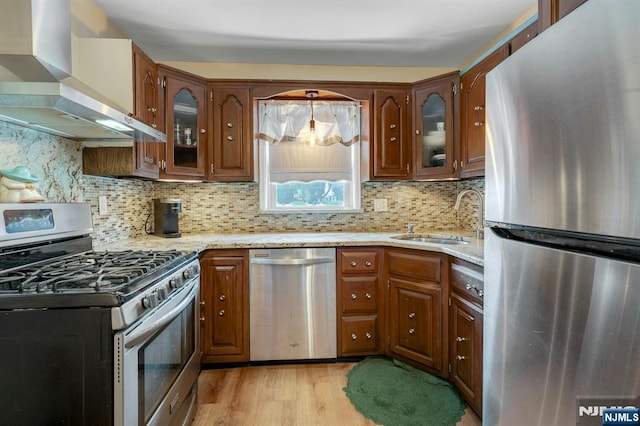 116 Springfield Ave, Hasbrouck Heights, NJ 07604 - kitchen with appliances with stainless steel finishes, wall chimney exhaust hood, light stone countertops, light wood-type flooring, and glass insert cabinets