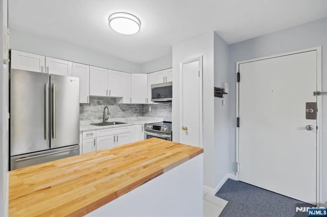 412-432 Broadway Unit 25A, Passaic, NJ 07055 - kitchen with stainless steel appliances, white cabinets, tasteful backsplash, and butcher block countertops