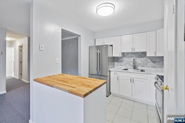 412-432 Broadway Unit 25A, Passaic, NJ 07055 - kitchen with freestanding refrigerator, stove, white cabinetry, tasteful backsplash, and butcher block counters