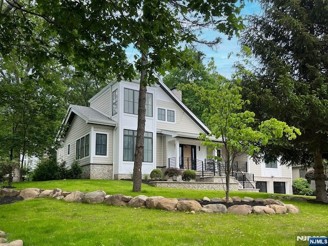 205 Pines Lake Dr, Wayne, NJ 07470 - view of front of home with a front lawn, a chimney, and covered porch