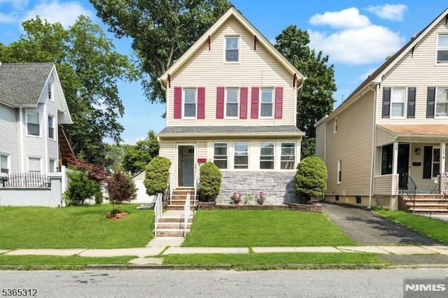28 E Westcott St, East Orange, NJ 07017 - view of front of home featuring stone siding, entry steps, and a front yard