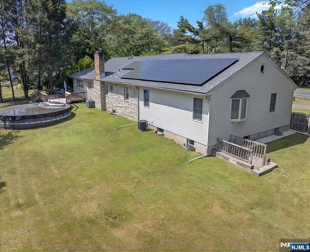 915 Glen Ave, Twp Of Washington, NJ 07676 - back of house with a chimney, an outdoor pool, solar panels, a shingled roof, and a wooden deck