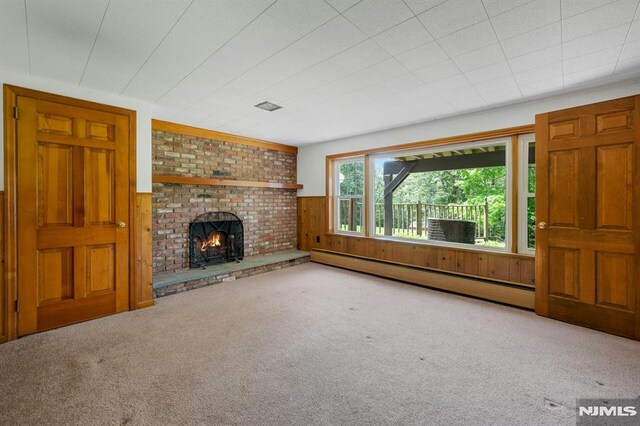 34 Tintle Rd, Kinnelon Borough, NJ 07405 - unfurnished living room featuring baseboard heating, wood walls, carpet flooring, and a fireplace