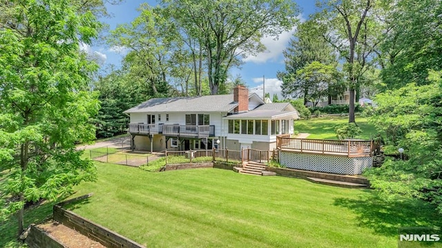 34 Tintle Rd, Kinnelon Borough, NJ 07405 - back of property featuring a deck, a lawn, a chimney, and a sunroom