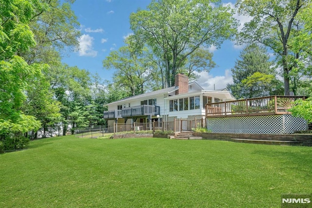 34 Tintle Rd, Kinnelon Borough, NJ 07405 - back of property featuring a wooden deck, a yard, a sunroom, and a chimney