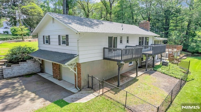 34 Tintle Rd, Kinnelon Borough, NJ 07405 - view of front facade featuring a chimney, roof with shingles, a garage, a deck, and asphalt driveway