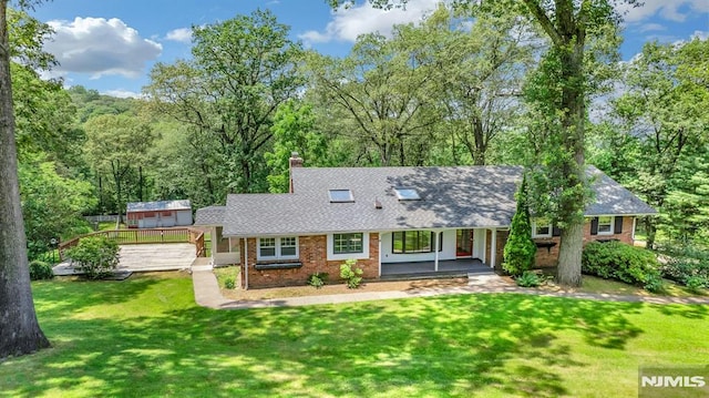 34 Tintle Rd, Kinnelon Borough, NJ 07405 - cape cod house featuring a porch, brick siding, a front lawn, a shingled roof, and a chimney
