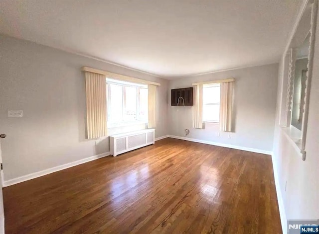 137 Prospect St, Lodi, NJ 07644 - spare room featuring radiator heating unit and dark wood finished floors