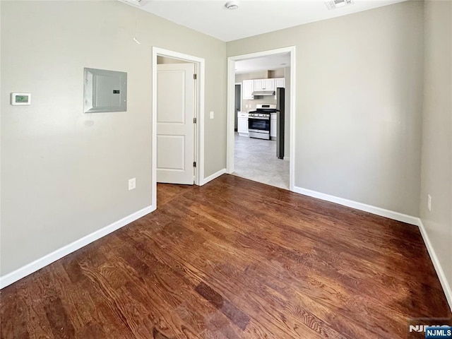 132 Lincoln Ave, Orange, NJ 07050 - spare room featuring electric panel, attic access, and wood finished floors