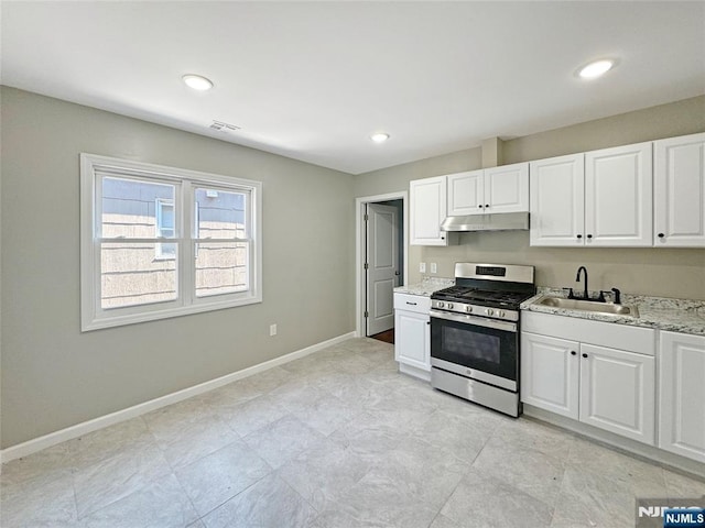 132 Lincoln Ave, Orange, NJ 07050 - kitchen featuring stainless steel range with gas cooktop, under cabinet range hood, white cabinets, light stone counters, and recessed lighting