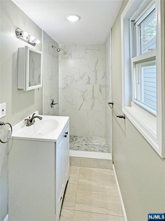 132 Lincoln Ave, Orange, NJ 07050 - bathroom featuring vanity and a marble finish shower