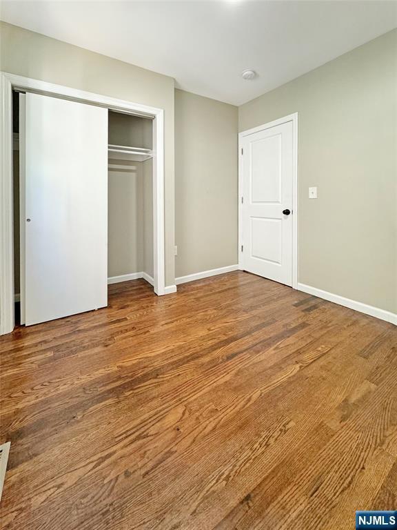 132 Lincoln Ave, Orange, NJ 07050 - unfurnished bedroom with a closet and wood finished floors