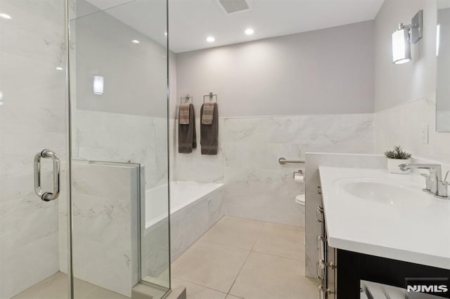 600 Harbor Blvd Unit 973/975, Weehawken, NJ 07086 - bathroom with vanity, a garden tub, a marble finish shower, tile patterned flooring, and tile walls