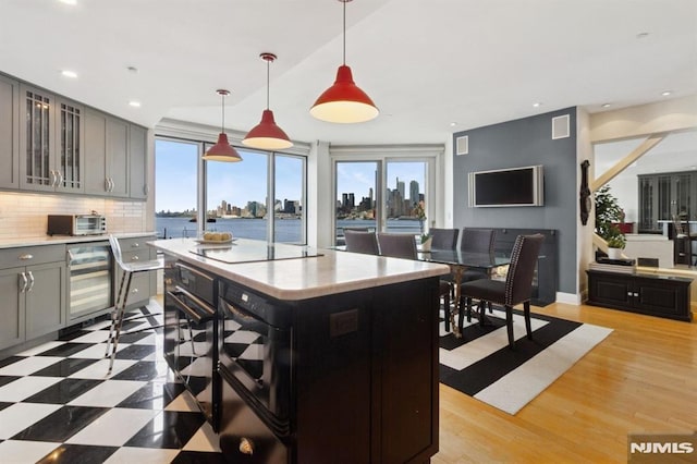 600 Harbor Blvd Unit 973/975, Weehawken, NJ 07086 - kitchen with wine cooler, light countertops, gray cabinetry, backsplash, and pendant lighting