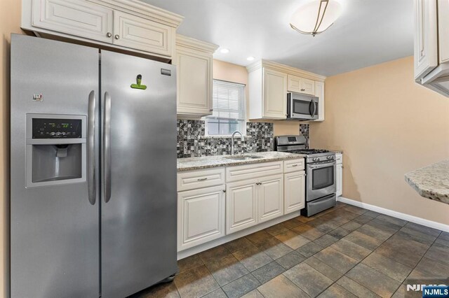 837 Keep St, Linden, NJ 07036 - kitchen with stainless steel appliances, tasteful backsplash, light stone counters, recessed lighting, and cream cabinets