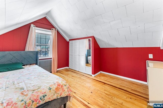 837 Keep St, Linden, NJ 07036 - bedroom featuring radiator heating unit, hardwood / wood-style floors, lofted ceiling, wooden walls, and a closet